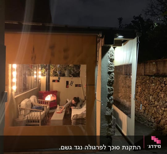 מרפסת עם סוכך בד צהוב ותאורה חיצונית